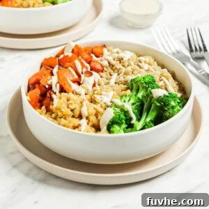 Healthy bowl with red lentils, quinoa, broccoli, carrot, squash and tahini sauce.