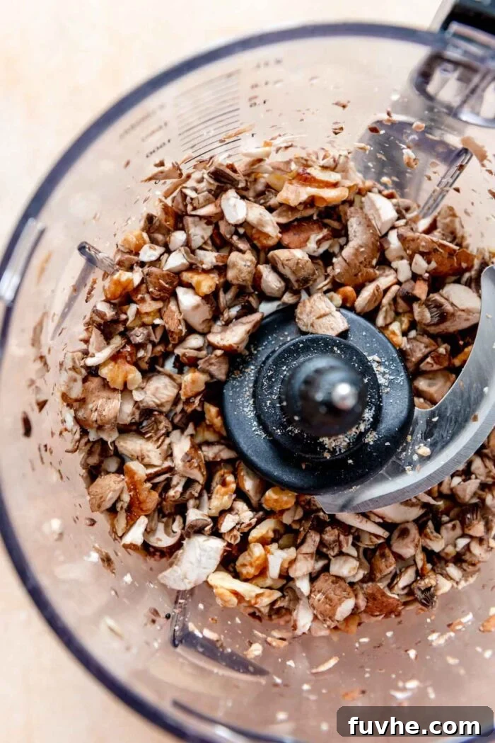Finely chopped mushrooms and walnuts in a food processor, ready to be seasoned for the vegan taco 'meat'.