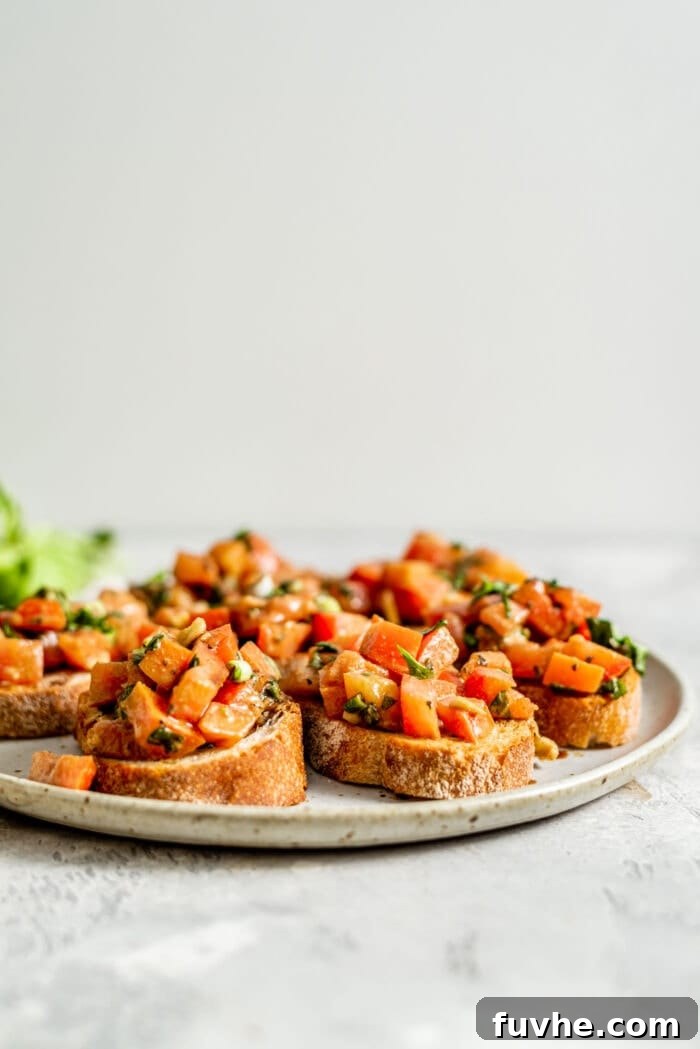 Freshly diced tomatoes, basil, and other ingredients for vegan bruschetta in a bowl.