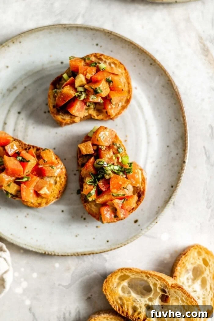 Several pieces of vegan bruschetta beautifully arranged on a white plate.