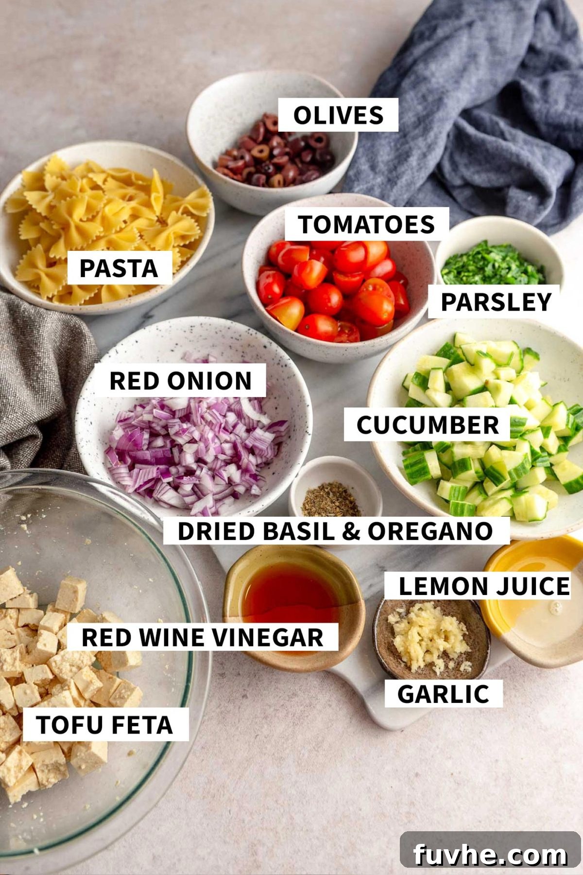 Plant-Based Greek Pasta Salad 3 All the ingredients for making a greek pasta salad with cucumber, tomato, red onion, parsley and tofu feta.