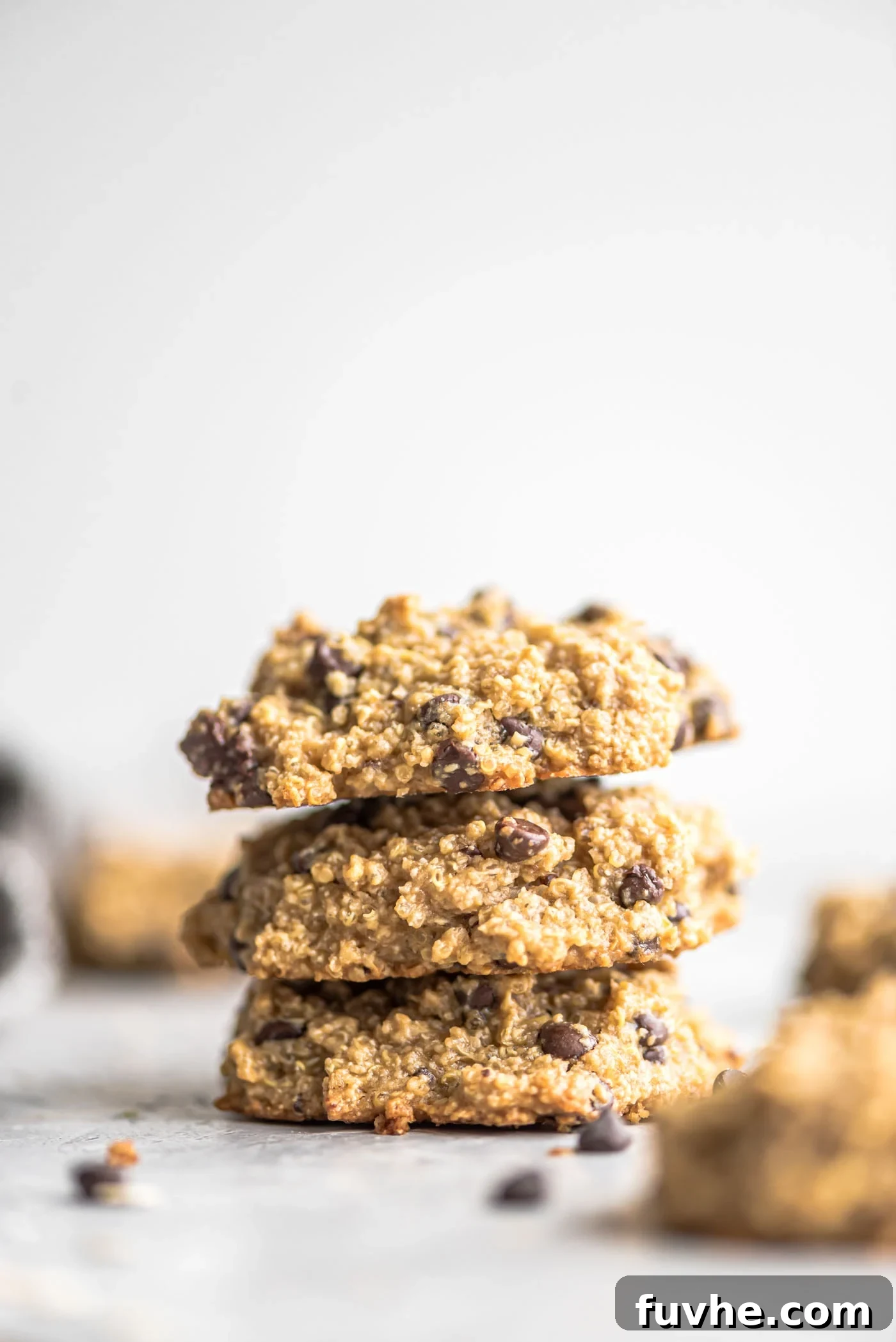 Plant-Powered Quinoa Chocolate Chip Cookies 2 Stack of three gluten-free vegan chocolate chip quinoa cookies against a grey background.