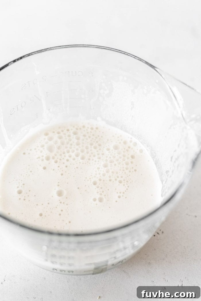 Large glass measuring cup with hemp seed milk in it.