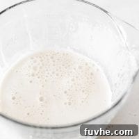 Large glass measuring cup with hemp seed milk in it.