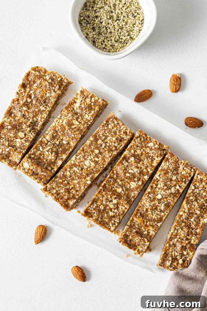 Six perfectly cut no-bake oatmeal energy bars displayed on parchment paper with a sprinkle of almonds.