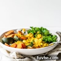 Bowl with lentils, roasted vegetables and kale against a white background.