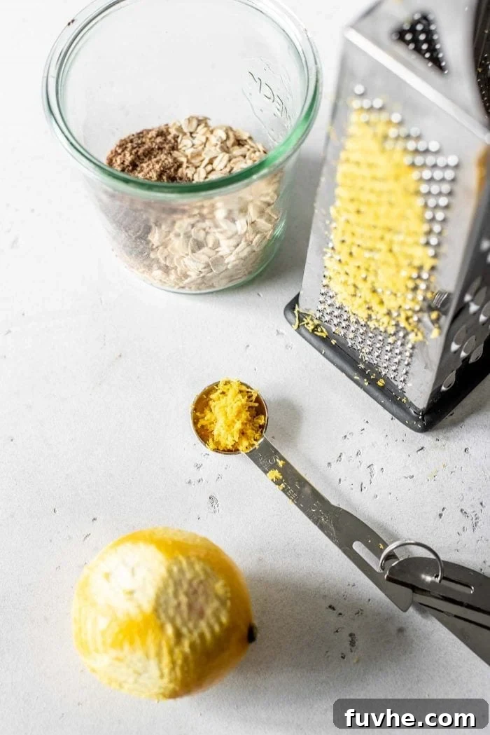 No-Bake Blueberry Muffin Oats 3 Lemon being grated to make fresh lemon zest for overnight oats.