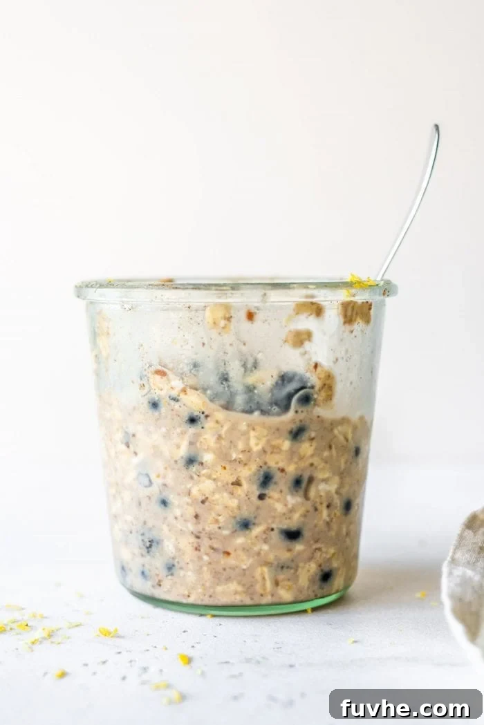 No-Bake Blueberry Muffin Oats 6 Glass jar filled with prepared blueberry overnight oats, topped with fresh blueberries.