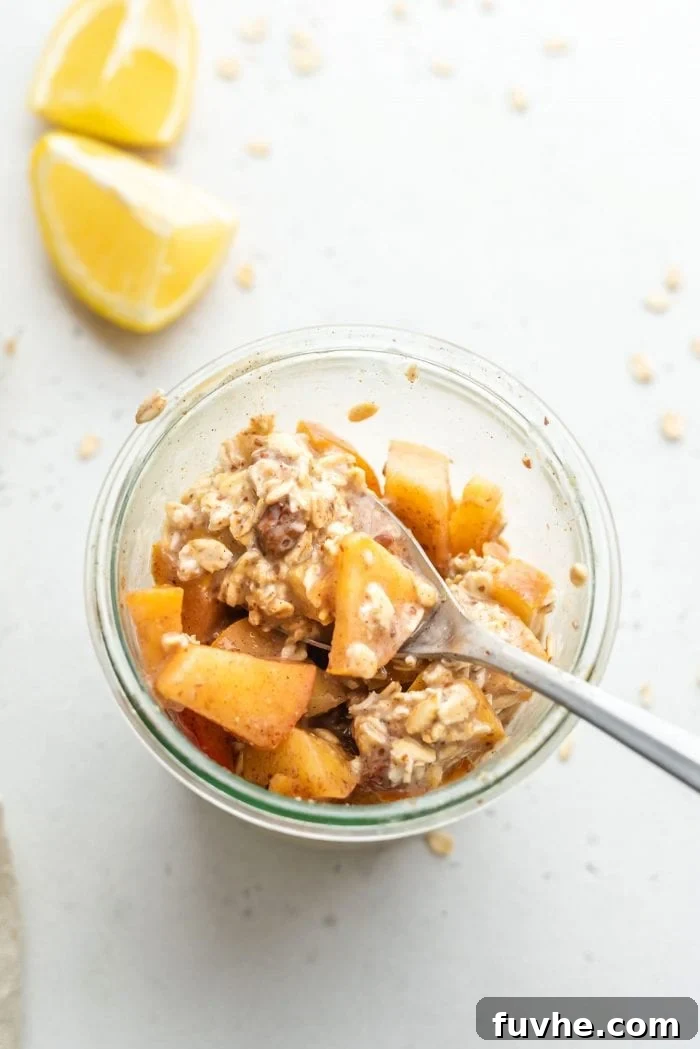 A glass container of perfectly prepared apple pie overnight oats, ready to be enjoyed.