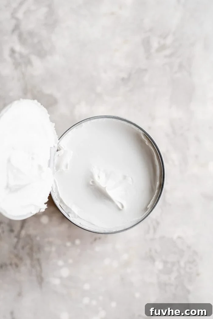 Thick coconut cream clearly separated in a can, ready to be scooped.