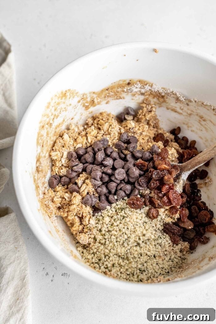 Bowl of cookie dough with chocolate chips, raisins and hemp seeds added, ready for baking.