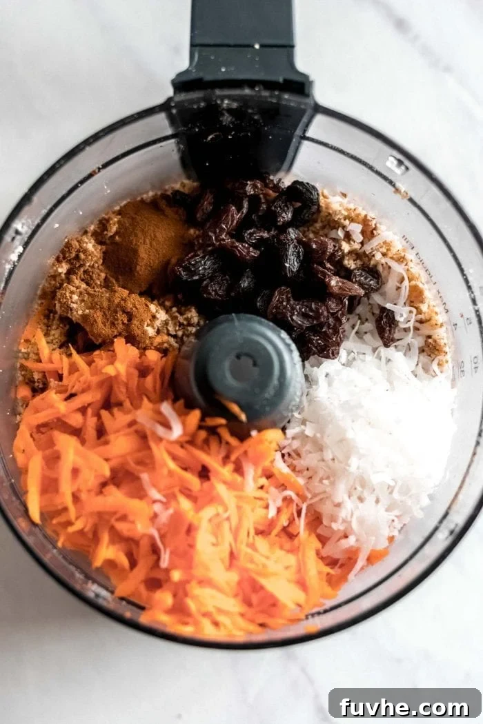 Ingredients for raw vegan carrot cake, including nuts, dates, and grated carrots, ready to be processed in a food processor.