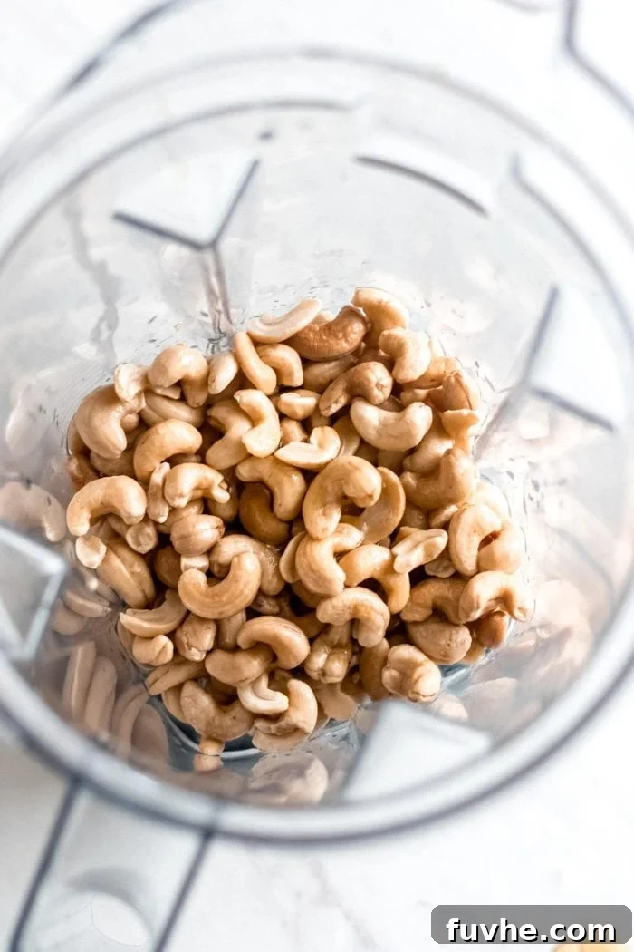 Soaked raw cashews waiting in a blender, ready to be transformed into a smooth, creamy cashew frosting for the carrot cake.