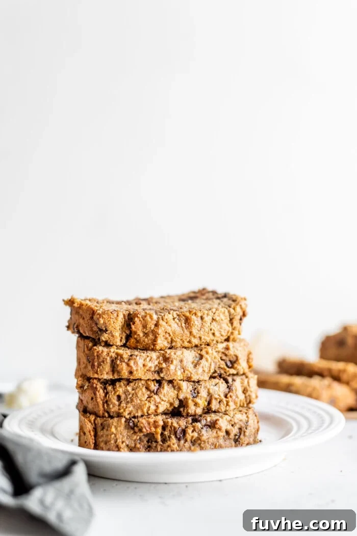Decadent Vegan Chocolate Chip Banana Loaf 14 A tempting stack of five perfectly cut slices of easy vegan banana bread, showcasing the wholesome ingredients and golden brown crust.