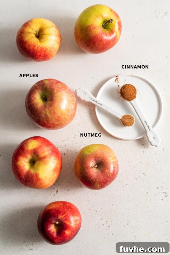 6 apples, 1 tsp of cinnamon and 1/2 tsp of nutmeg on a white surface.
