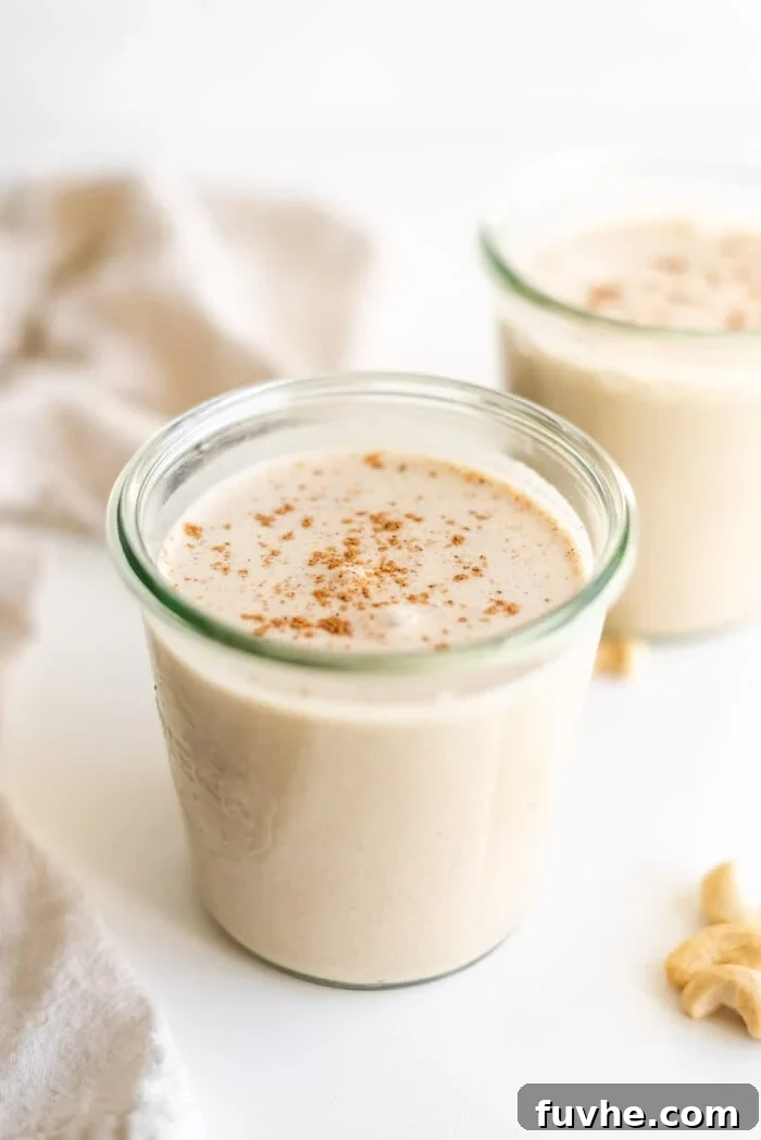 Festive Vegan Nog 2 Two glasses of healthy, homemade vegan eggnog garnished with cinnamon.