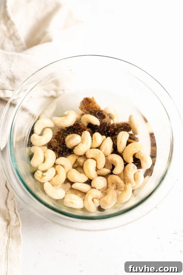 Festive Vegan Nog 6 Raw cashews and pitted dates soaking in a glass bowl of water.