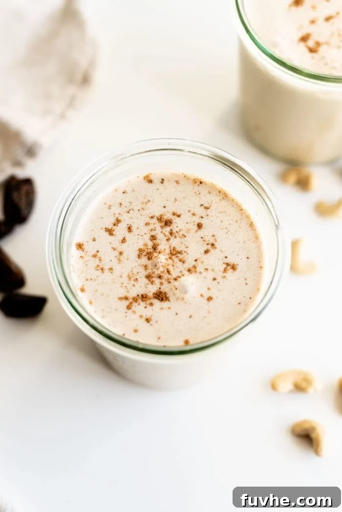 Festive Vegan Nog 8 A single glass of healthy, spiced vegan eggnog topped with cinnamon.