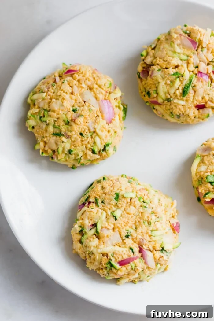 4 raw veggie burger patties on a plate.
