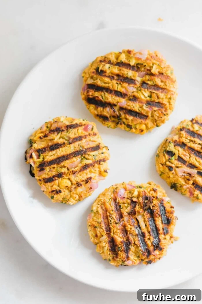 4 cooked chickpea veggie burger patties on a plate.