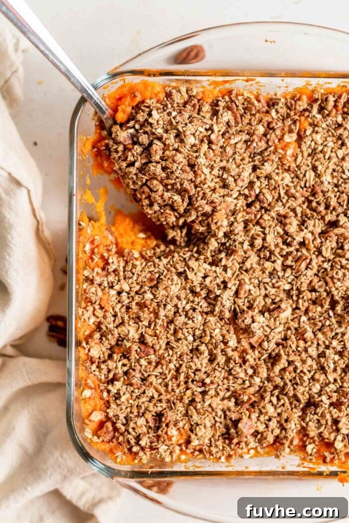 Golden Vegan Sweet Potato Comfort 2 A spoon scooping sweet potato casserole out of a baking dish.