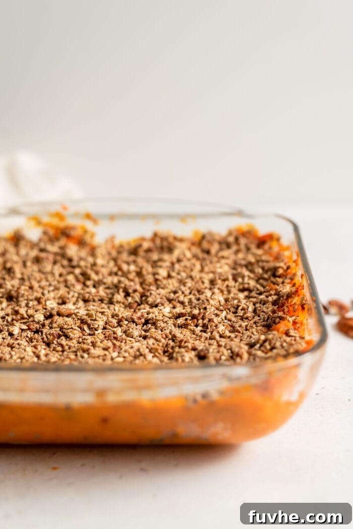 Golden Vegan Sweet Potato Comfort 11 Pecan and oat sweet potato casserole in a baking dish.