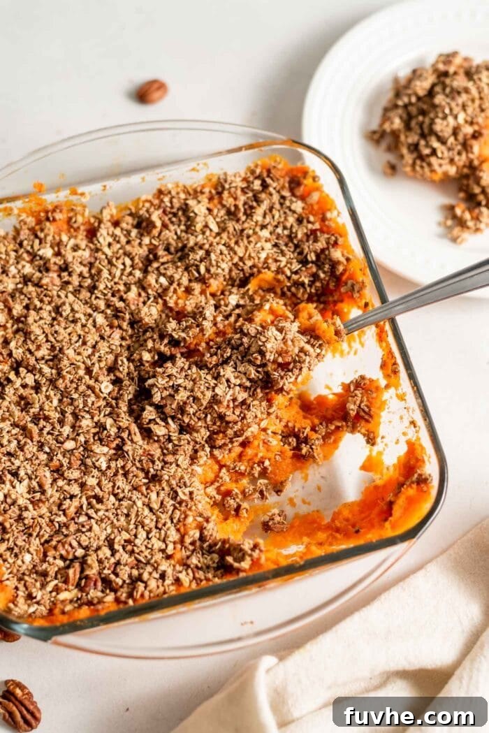 Golden Vegan Sweet Potato Comfort 3 A serving spoon scooping out healthy vegan sweet potato casserole from a baking dish.