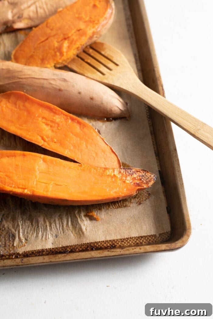 Golden Vegan Sweet Potato Comfort 5 Roasted sweet potato on a baking tray lined with parchment paper.