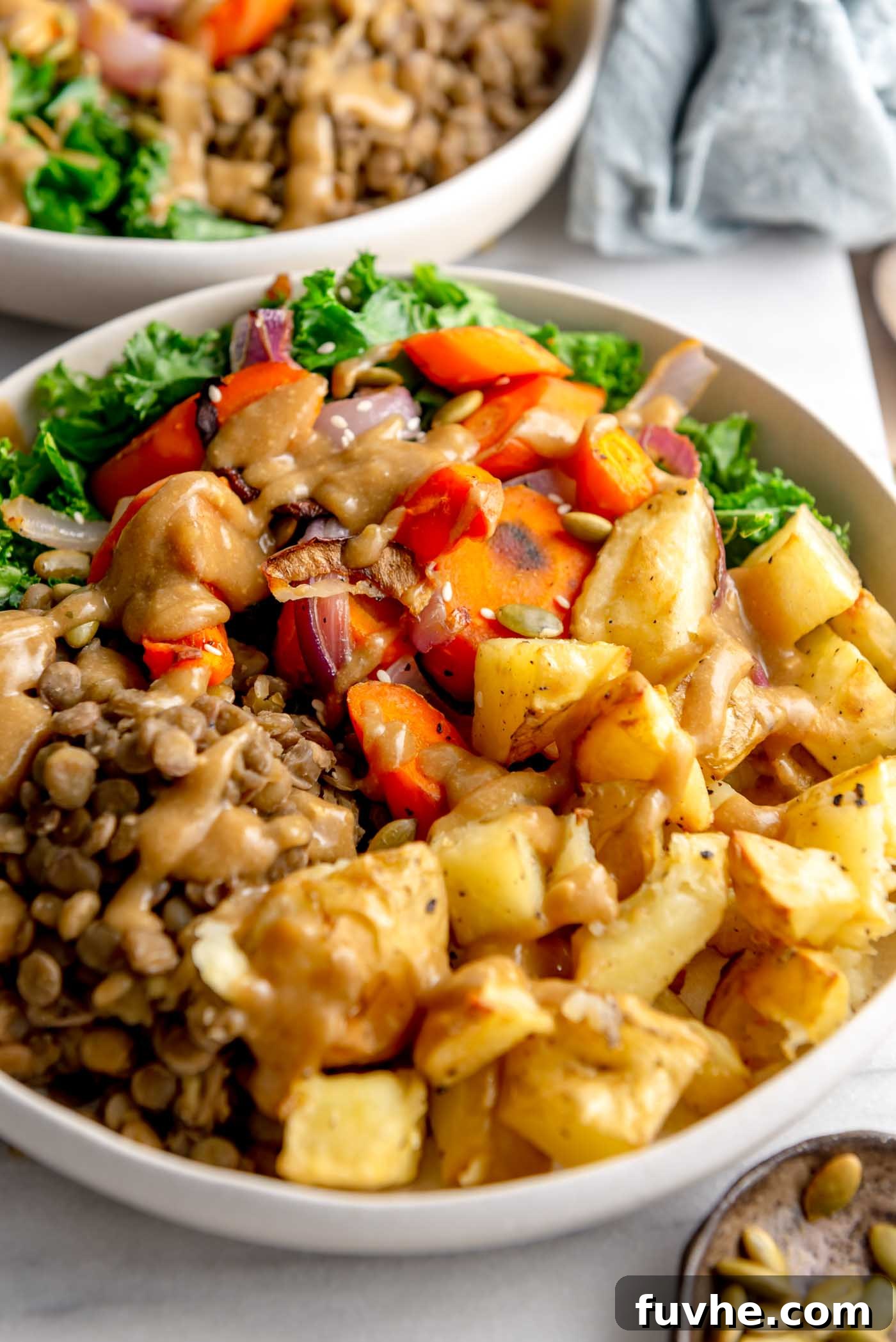 Vegan Lentil Power Bowl 2 Healthy vegan bowl with roasted potatoes, roasted onion and carrot, lentils, kale and gravy, presented beautifully.