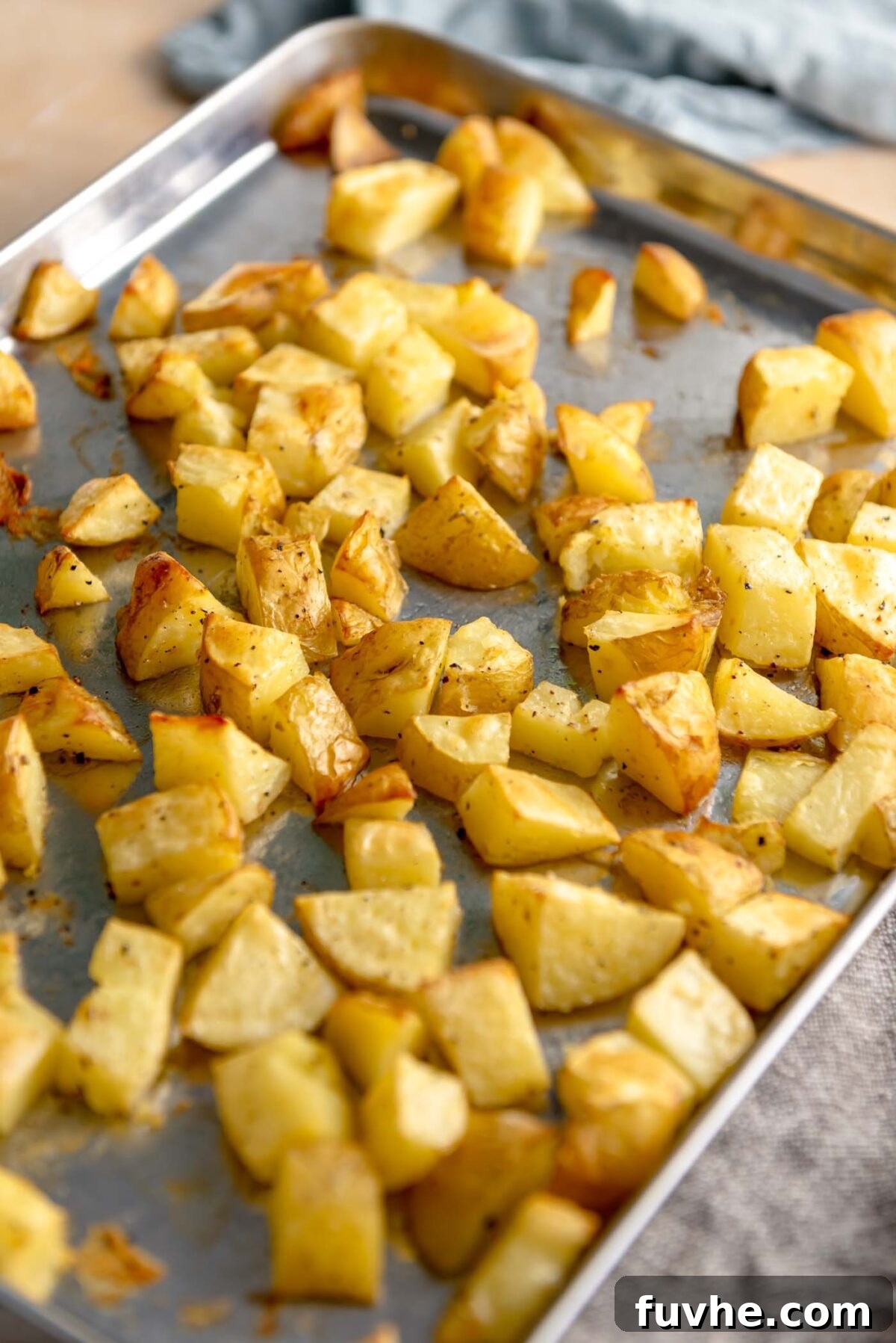 Vegan Lentil Power Bowl 5 Chopped potato chunks spread on a baking sheet, ready for roasting.