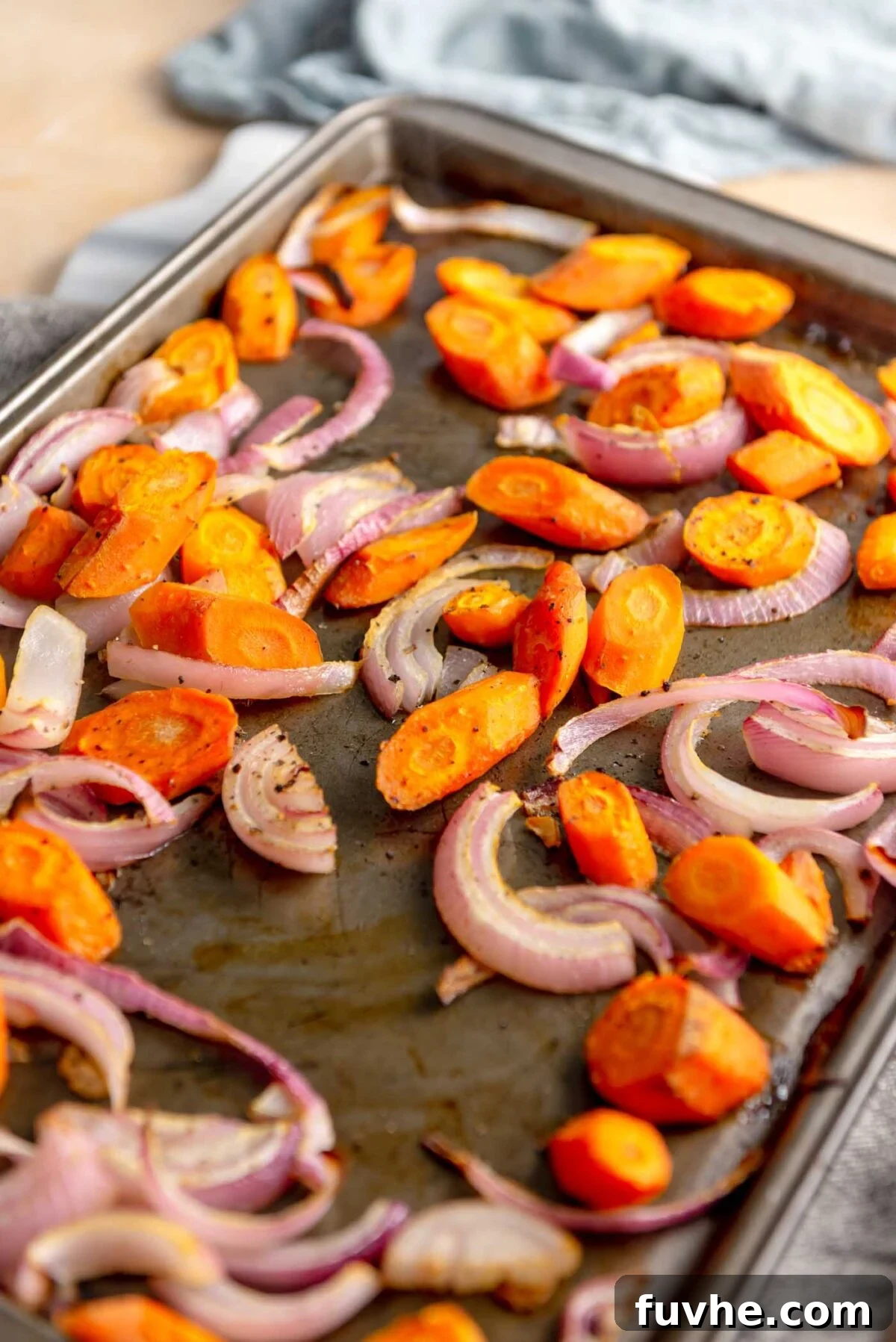 Vegan Lentil Power Bowl 6 Chopped onion and carrot pieces arranged on a separate baking sheet for roasting.