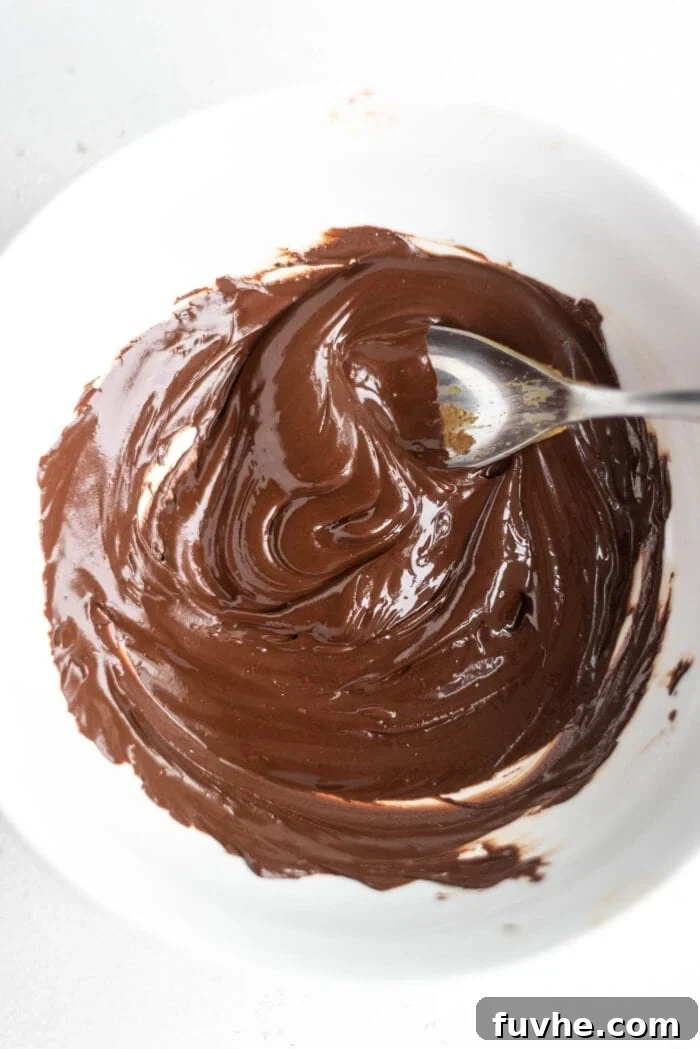Smooth, melted dairy-free chocolate in a white ceramic bowl, ready for dipping.