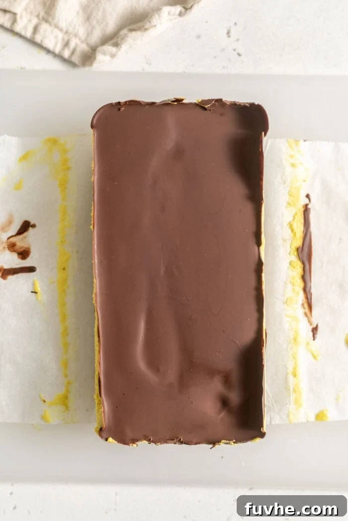 Vegan Nanaimo Bar Delight 11 A block of homemade vegan Nanaimo bars on a cutting board.