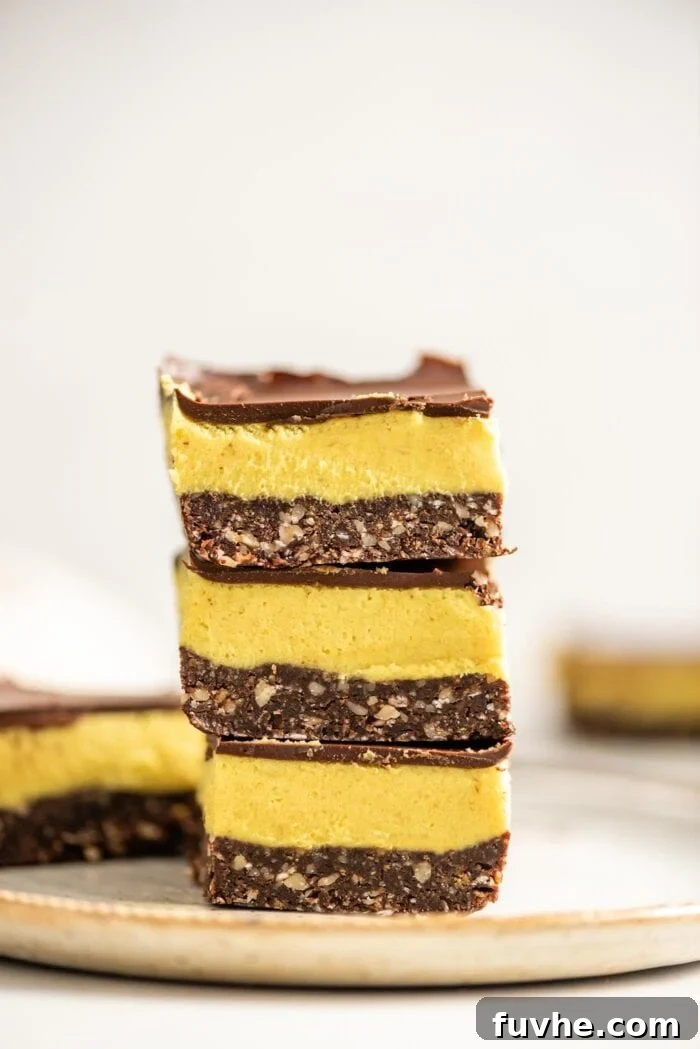 Vegan Nanaimo Bar Delight 13 A stack of vegan Nanaimo bars on a small grey plate.