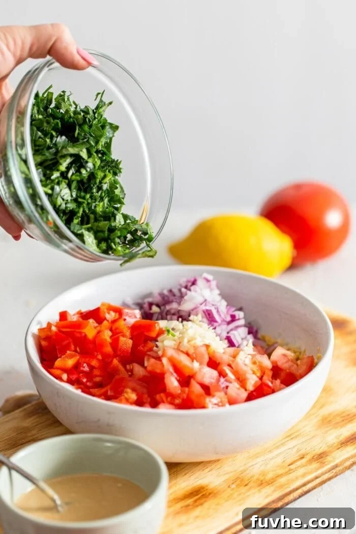 High-Fiber Powerhouses 5 A bowl of chopped parsley being added to a bowl of fresh chopped veggies.