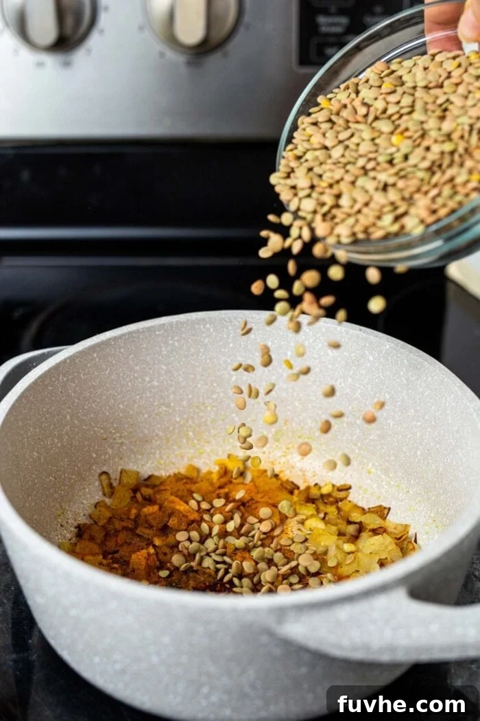 High-Fiber Powerhouses 7 A dish of dry green lentils being dumped into a pot on the stovetop.