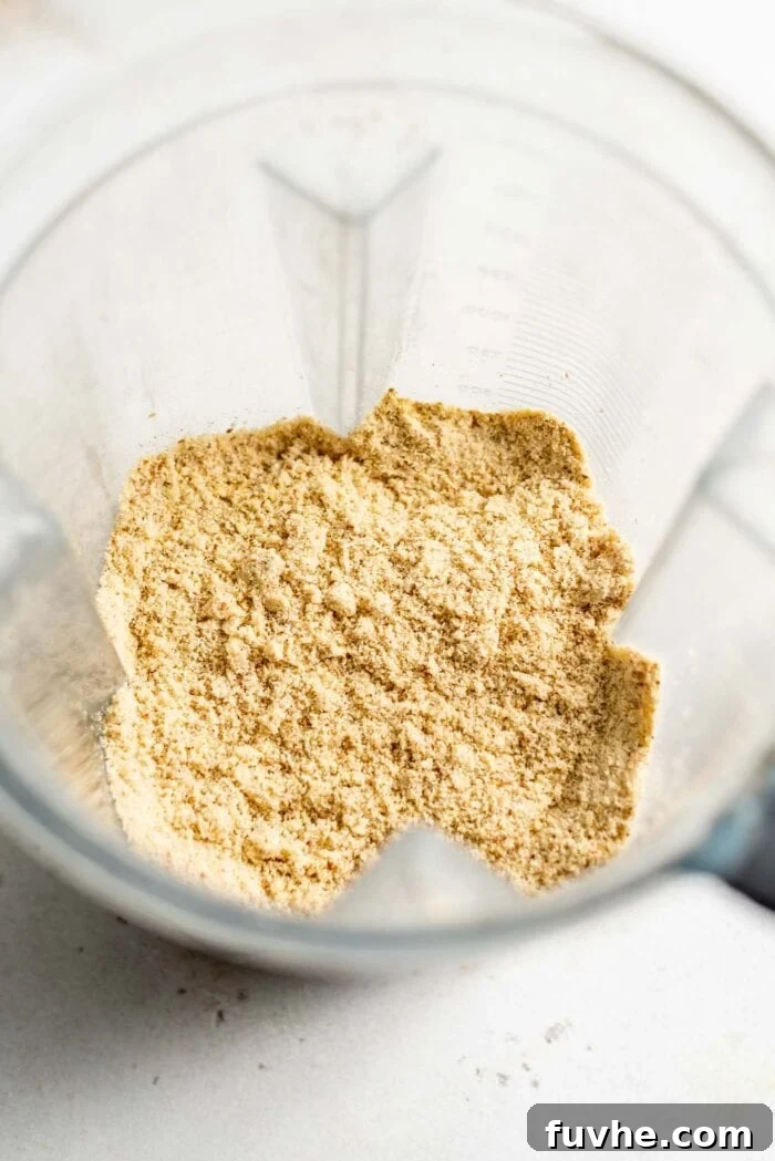 Plant-Based Parm Perfection 5 Perfectly blended vegan parmesan cheese within a high-speed blender, showcasing its fine texture.
