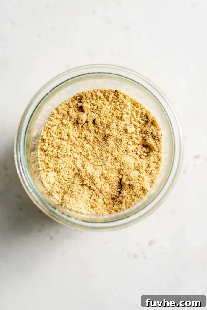 Plant-Based Parm Perfection 7 Vegan almond parmesan gracefully stored in an elegant glass jar, highlighting its fine texture.