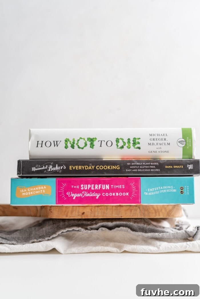 A stack of heavy books providing weight on a wrapped block of tofu.