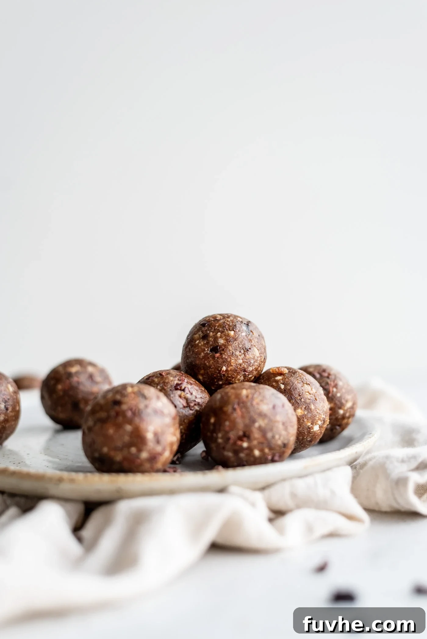 Hazelnut Fuel Bites 2 A beautifully arranged plate brimming with dark chocolate hazelnut energy balls, showcasing their rich texture and inviting appearance.