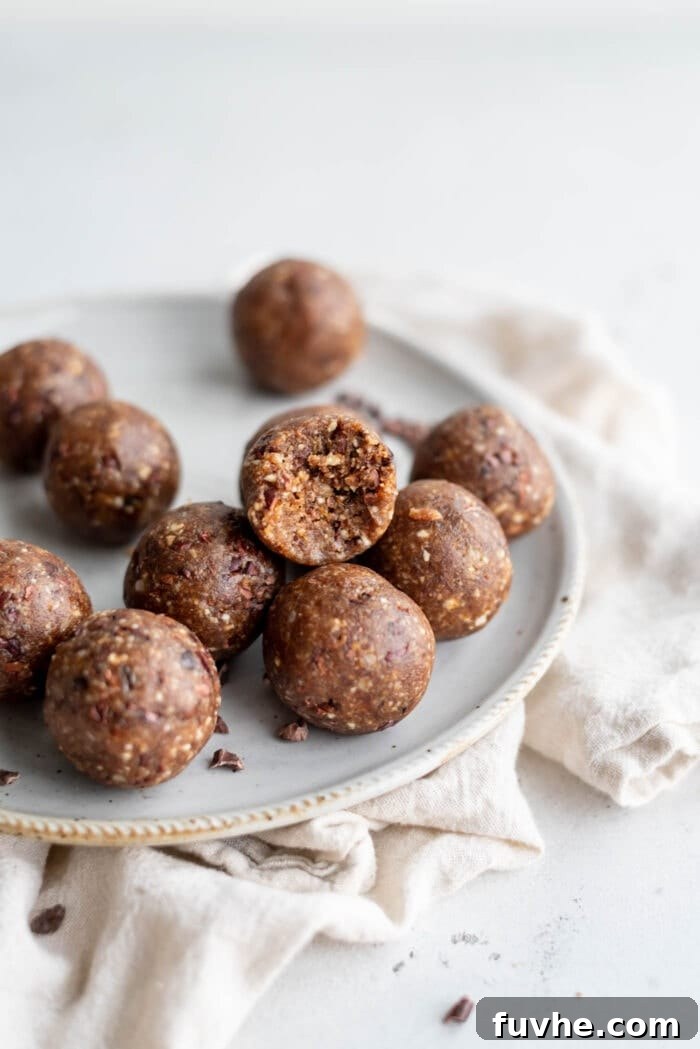 Hazelnut Fuel Bites 5 A perfectly formed hazelnut energy ball with a small bite taken out, resting on a rustic plate.
