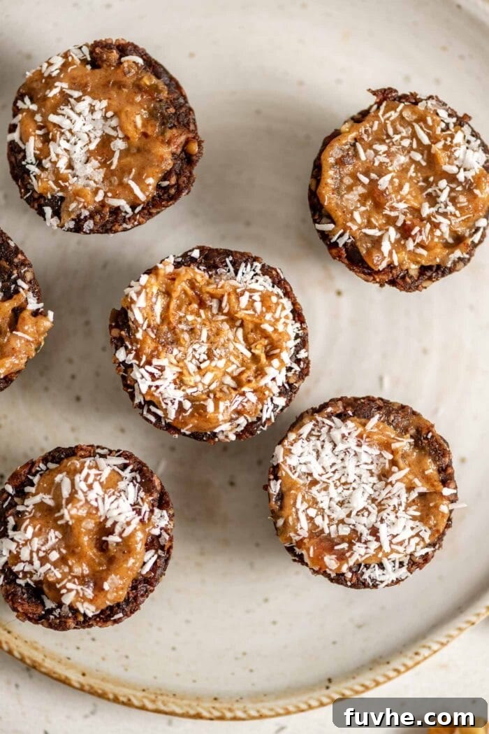 Effortless Chocolate Caramel Temptations 2 Chocolate tarts with a caramel filling topped with coconut on a small plate.