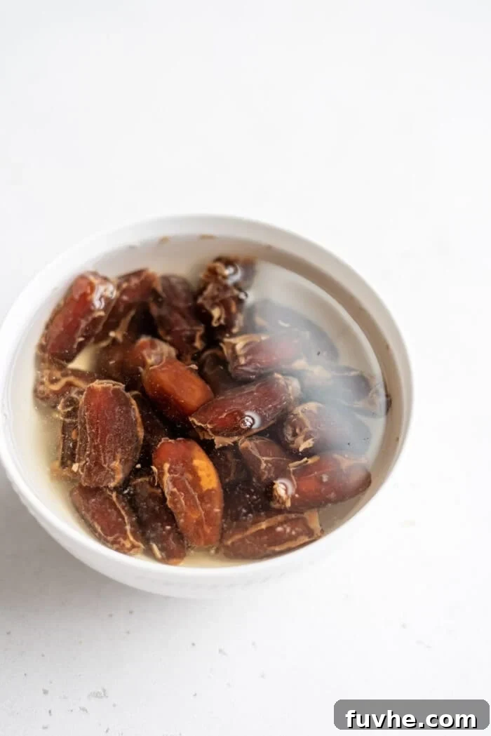 Effortless Chocolate Caramel Temptations 4 Dates soaking in a bowl of water.