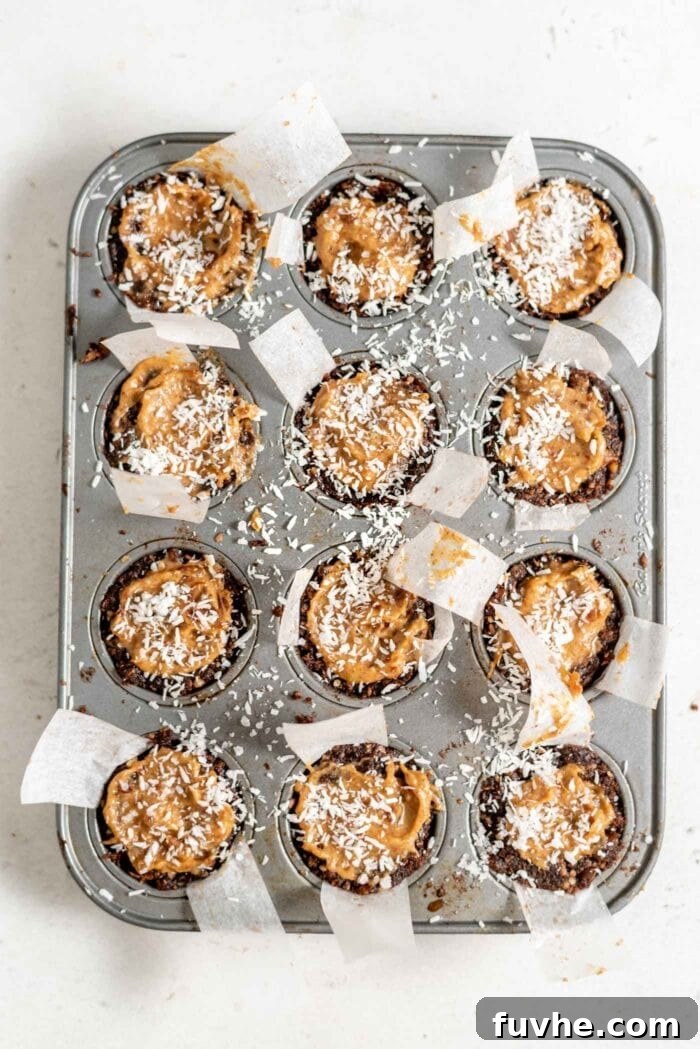 Effortless Chocolate Caramel Temptations 9 Caramel tarts topped with coconut in a muffin tin.