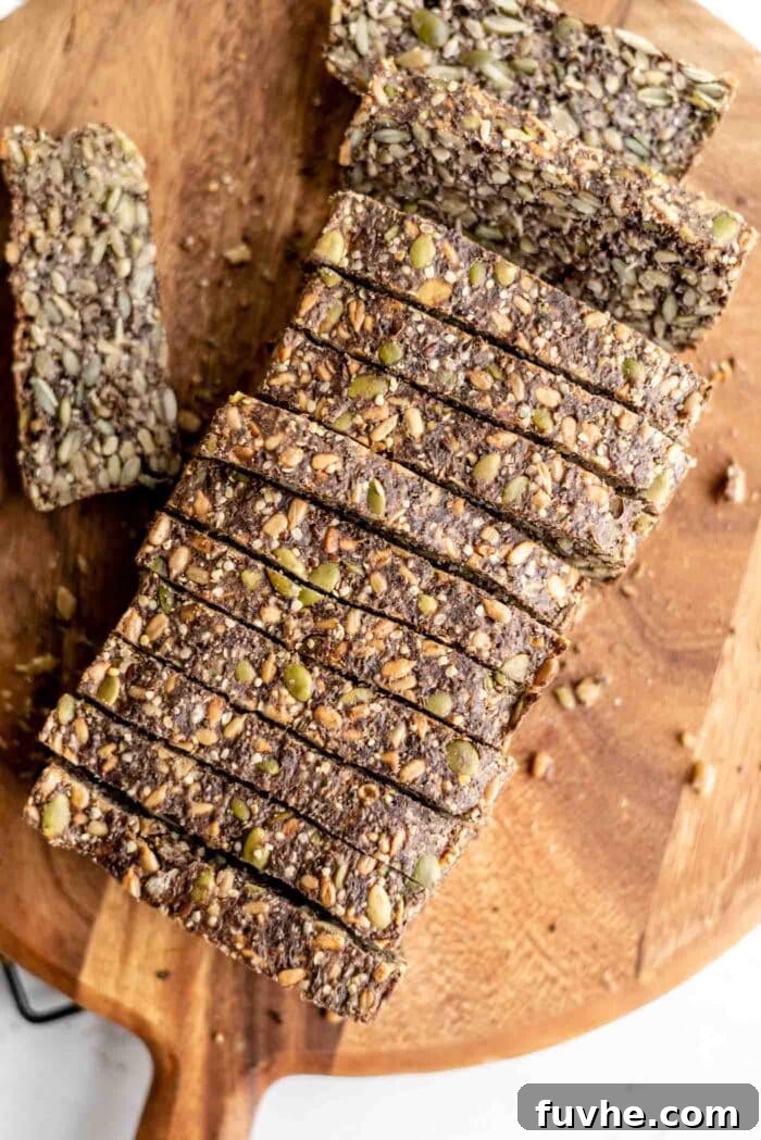 A freshly baked, rustic loaf of seed bread, sliced into perfect portions, elegantly arranged on a wooden cutting board, ready for serving or storage.