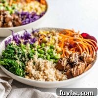 Wholesome Vegan Tempeh Buddha Bowl 8 A vibrant Vegan Tempeh Buddha Bowl, featuring a medley of brown rice, edamame, crispy tempeh, and fresh vegetables, drizzled with a rich tamari tahini dressing and sesame seeds.