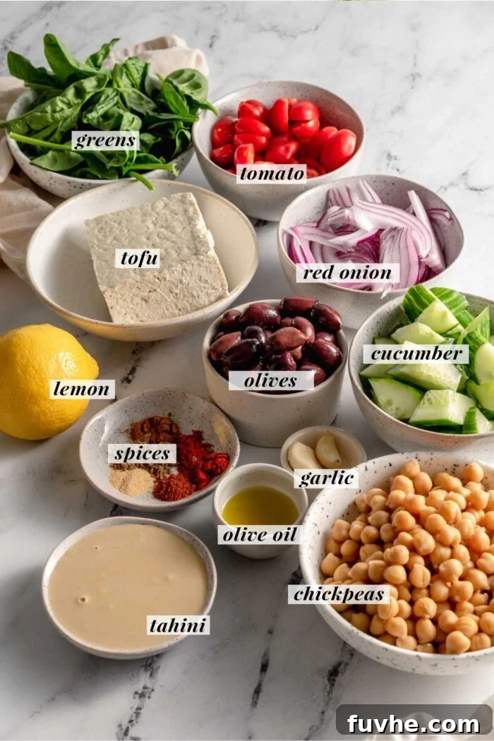 All the necessary fresh ingredients for preparing vegan hummus buddha bowls, including tofu, homemade hummus, and a variety of colorful vegetables, laid out appealingly on a surface.
