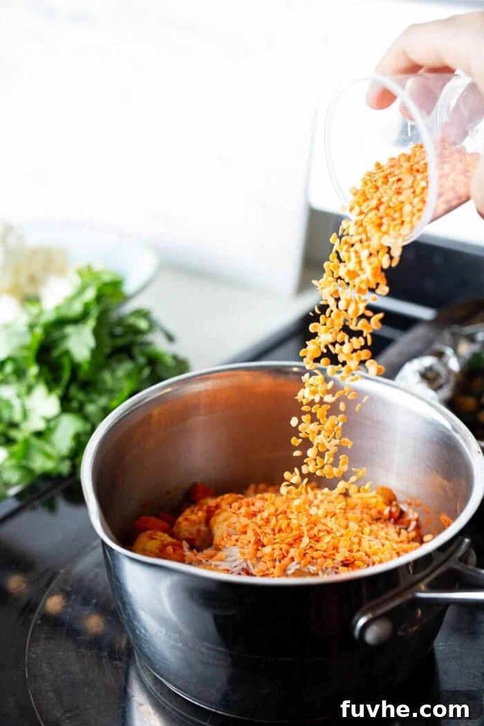 Iron Rich Vegan Foods 9 Adding red lentils to a pot of cauliflower curry stew.