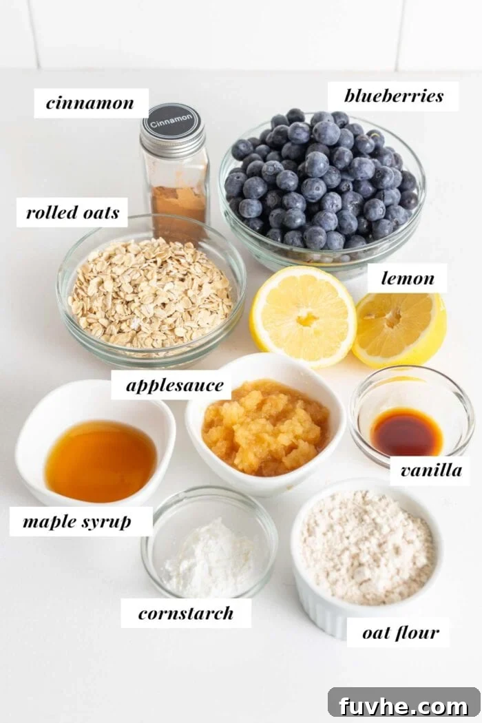 Wholesome Vegan Blueberry Crumble 3 Fresh blueberries, rolled oats, oat flour, cinnamon, applesauce, and maple syrup arranged in dishes on a kitchen counter, showcasing the ingredients for a healthy vegan blueberry crisp.