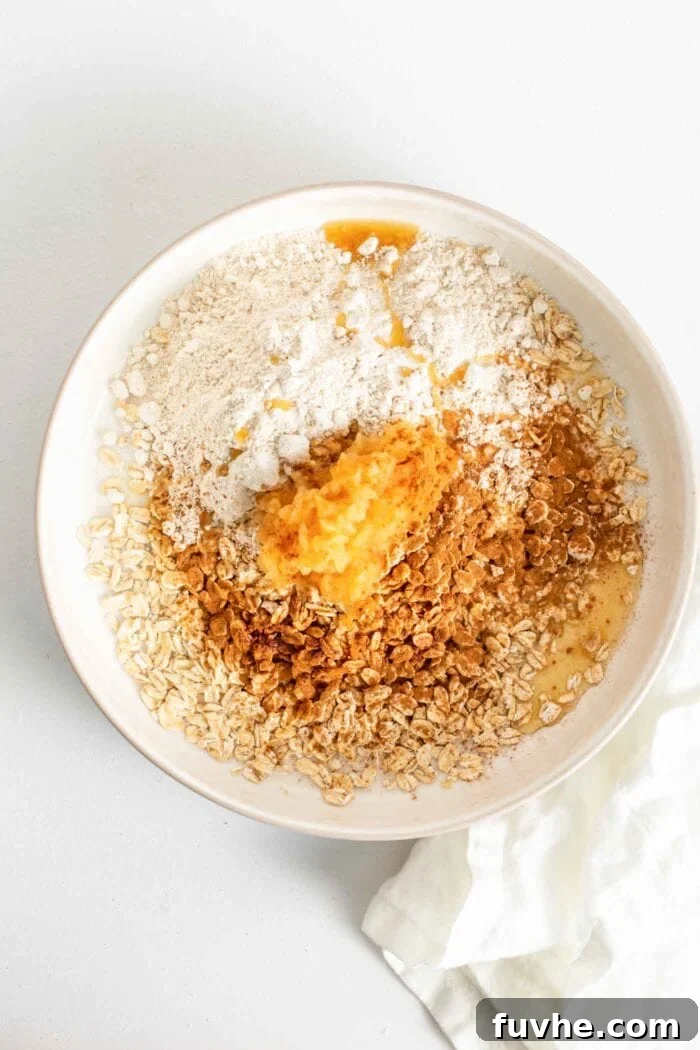 Wholesome Vegan Blueberry Crumble 5 Rolled oats, oat flour, maple syrup, unsweetened applesauce, and vanilla extract combined in a mixing bowl, forming the wholesome crumble topping.